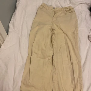 Beige byxor från Lindex - Snygga beige byxor från Lindex i en klassisk stil. Byxorna har en rak passform och är tillverkade i ett mjukt material som ger en bekväm känsla. Perfekta för en avslappnad look.