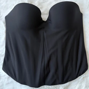 Svart bandeau-bh från H&M - Snygg och jätte trendig svart bandeau/korsett från H&M med avtagbara axelband, st 75B vilket är en xs/s. helt ny med prislapp kvar har ej haft tillfälle att använda den drf säljs den 