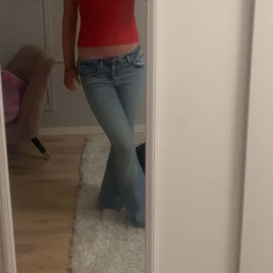 Blå bootcut jeans från Zara - Snygga ljusblå bootcut jeans från Zara Basic. De har en klassisk femficksdesign och är tillverkade i denim. Perfekta för en avslappnad stil.