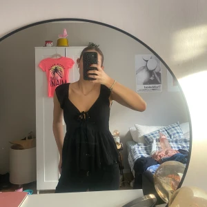 Svart ärmlös topp med knytning - Snygg svart ärmlös topp med knytning .