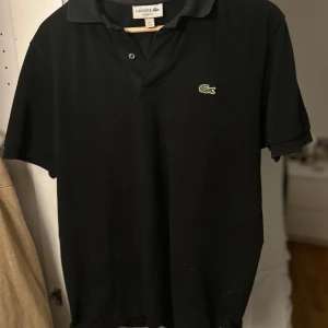 Piké. Lacoste piké. - En svart piké från Lacoste. Stilren och snygg. Den är storlek M och är för liten för mig därför säljs den. Pikén i sig har ett mycket fräscht skick. Ny prisa ligger på cirka 1200kr mitt pris är 399kr