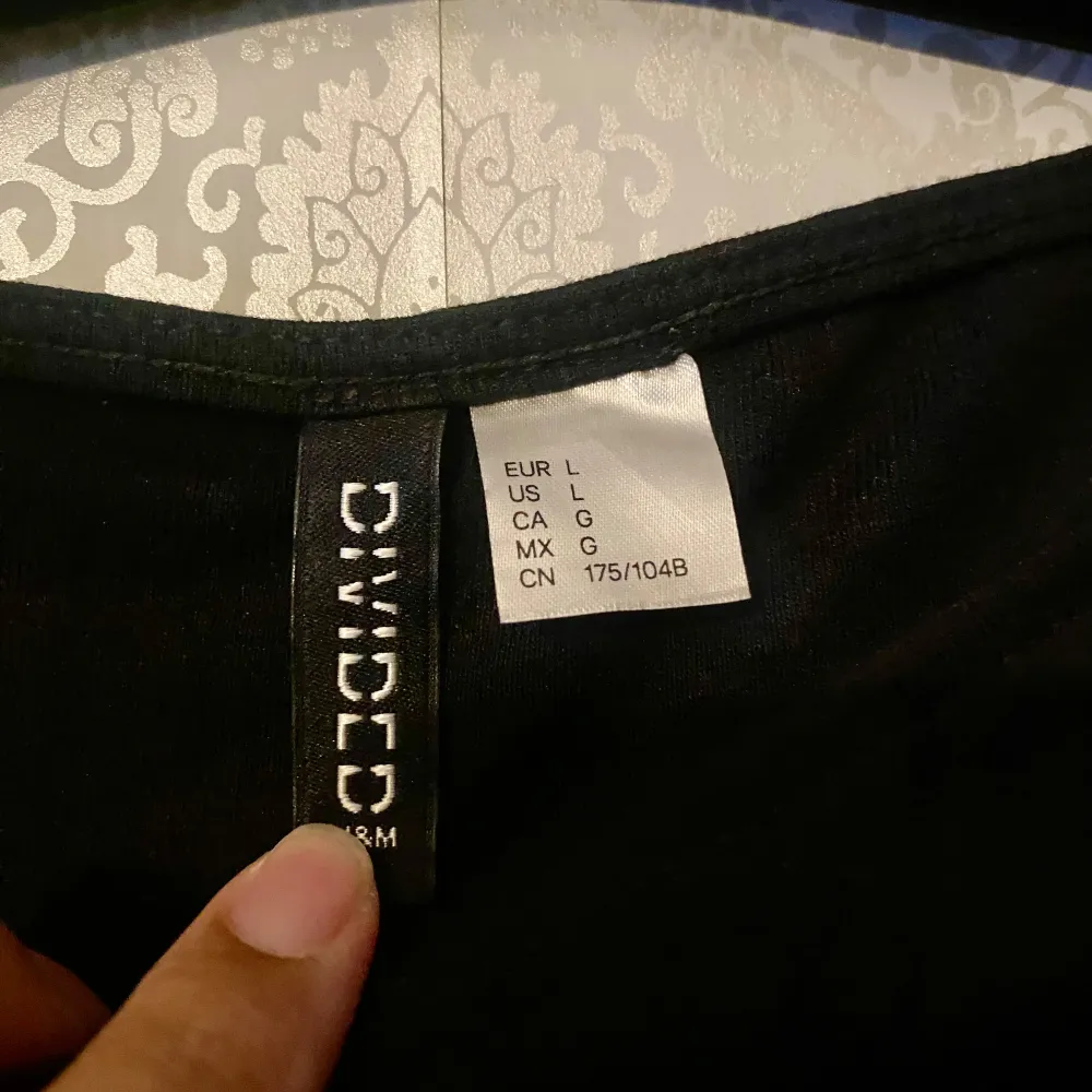 Säljer en stilren svart långärmad topp från H&M Divided. Toppen har en rynkad detalj på sidorna som ger en snygg effekt. Perfekt för att matcha med olika outfits. 🖤. Yläosat.