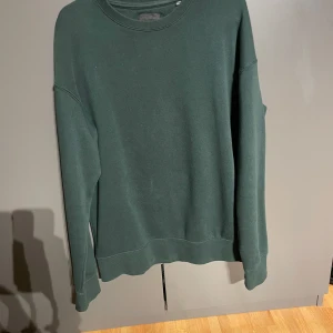 Jack&Jones Sweatshirt - Säljer en stilren mörkgrön tröja från Jack & Jones då den inte har kommit till användning. Tröjan har en klassisk rund hals och långa ärmar, perfekt för en avslappnad look. Pris ej hugget i sten.