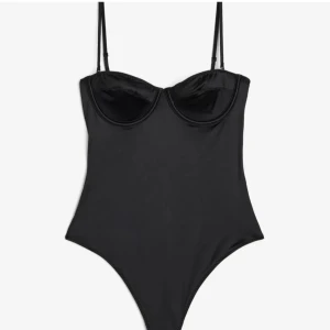 Svart body från H&M - Snygg svart body från H&M med justerbara axelband och bygel för extra stöd. Perfekt för en stilren look. Tillverkad i ett mjukt och stretchigt material för bästa komfort.