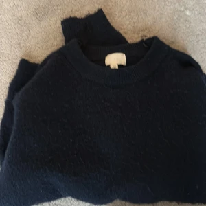 Mörkblå stickad tröja från H&M - Mysig mörkblå stickad tröja från H&M i storlek M. Tröjan har rund halsringning och långa ärmar, perfekt för kyliga dagar. Enkel och stilren design som funkar till många olika outfits. Känns mer som en s💗