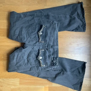 True Religion bootcut jeans - Säljer ett par gråa True Religion jeans då jag kntr vill ha dem längre. Bakfickorna har snygga detaljer med nitar även framsidan. Inga defekter på jeansen, skriv privat för frågor.