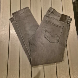 Replay jeans hyperflex - Snygga grå jeans från Replay, modell Hyperflex Anbass. De har klassisk femficksdesign, raka ben och normal passform. Jeansen är tillverkade i stretchigt material för extra komfort och har Replay-logga på fickan.