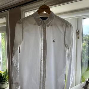 Vit skjorta från Ralph Lauren - Klassisk vit skjorta från Ralph Lauren i 100% bomull. Skjortan har lång ärm, Det är en storlek M ’en sitter även bra som S. Den är inte använd nått. Skickar inom 1 dag efter ni beställer