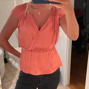 Persikofärgad topp med knyt - Supersöt persikofärgad omlottopp med v-ringning🧡🧡