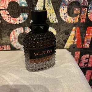 Valentino parfym 50 ml - Snygg parfymflaska från Valentino på 50 ml. Flaskan är i glas med nitar och har en mörk tonad färg som går från svart upptill till klar nedtill. Märket står tydligt på etiketten. Perfekt för dig som gillar lyxiga och stilrena dofter. Flaskan är använd men är runt 40ml kvar. Har inte original lådan då den har gått sönder men den fraktas säkert och bra förvarat. Skriv vid frågor eller funderingar. 