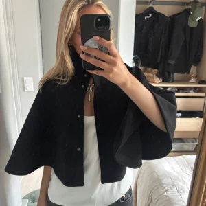 Svart cape Zara - Säljer en svart cape från Zara, perfekt att slänga över en klänning eller linne. Aldrig använt