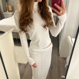 Vitt ribbat set - Säljer ett vitt ribbat nästintill oanvänt set från SHEIN💗💗Kjolen är i storlek S och tröjan i XS🫶 Tröjan sitter tight och har en lite högre krage och kjolen slutar strax under knäna