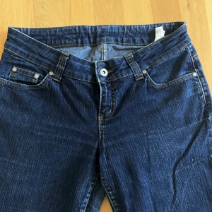 Blå bootcut jeans från Vero Moda - Snygga mörkblå bootcut jeans från Vero Moda med klassisk femficksdesign och kontrastsömmar. Jeansen har låg midja och är tillverkade i ett slitstarkt denimtyg. Skriv om frågor! :)