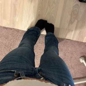 Blå bootcut jeans i xs - Säljer ett par blå bootcut jeans från Gina tricot, perfect jeans. Modellen har medel till låg midja och utsvängda ben, vilket ger en snygg retrovibe. Jeansen har fem fickor, dragkedja och knapp i midjan. De har en smalare passform.