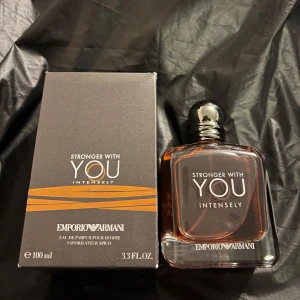 Emporio Armani Stronger With You Intense - Emporio Armani Stronger With You Intensely EdP 100 ml. Flaskan är fyrkantig i tjockt glas med bärnstensfärgad vätska och silverfärgad kork. Snygg och modern design med svart och orange kartong. En maskulin doft med intensiv karaktär.
