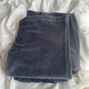 Mörkgrå mjukisbyxor från Gina Tricot - Supermjuka och sköna mörkgrå mjukisbyxor från Gina Tricot med bred resår i midjan och raka, lite vidare ben. Perfekta för chill eller hemmadagar. Tillverkade i fleece-liknande polyester för extra mysfaktor.