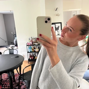 Ljusgrå stickad tröja med rund hals - Supermjuk och stilren ljusblå stickad tröja med rund halsringning och långa ärmar. Tröjan har en ribbad struktur och en relaxed passform som är perfekt för lager-på-lager. Enkel att matcha med både jeans och kjol.