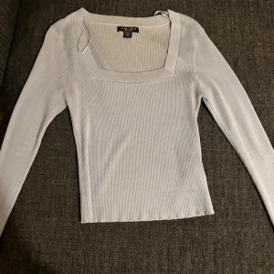 Ljusblå  ribbad långärmad tröja  - Supersnygg vit ribbad tröja från Amisu med fyrkantig ringning och långa ärmar. Perfekt att styla med jeans eller kjol för en clean och fräsch look. Stretchigt material som sitter skönt och följer kroppen.