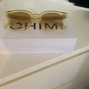 Gula solglasögon från CHIMI - Snygga solglasögon från CHIMI i transparent gul plast med fyrkantig form. Box och fodral medföljer.