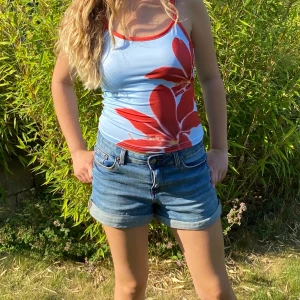 Sommar blommigt linne - Snyggt blått linne med röda blommor. XS, helt ny. Skulle säga att den passar S också. Väldigt trendig. 