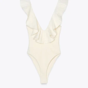 Body Zara med volang stl S, HELT NY - Supersnygg v-ringad body från Zara, helt ny med prislappen kvar. Naturfärgad.