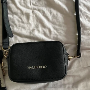 Väska Valentino - Fin väska från valentino, finns 2 band att byta till, det svarta och den vita tjockare med valentino text på. Ny pris 1295kr