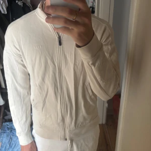 Hugo Boss Zip - Säljer en beige Hugo Boss zip kofta i Storlek M, sitter dock som en S, fint skick. Hämtas i Gamla Enskede eller fraktas.
