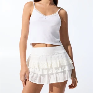 Vit mini volangkjol - Superfin vit kortkjol från Pull&Bear med flera lager volanger och broderade spetsdetaljer upptill. Helt ny med prislapp kvar