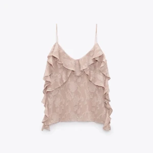 Beige volanglinnetopp - Säljer en superfin ljus rosa linnetopp med volanger. Perfekt för sommardagar eller en festlig kväll. Den har tunna axelband och ett vackert blommigt mönster. Toppen är i mycket bra skick och ger en romantisk touch till vilken outfit som helst.🩷🩷