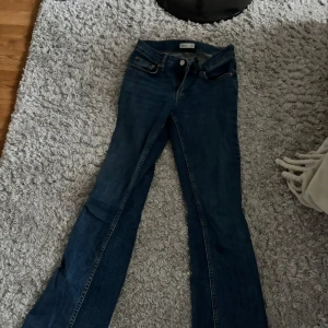 Jeans Gina Tricot - Snygga blå jeans från Gina Tricot med bootcut passform och klassisk femficksdesign. Jeansen har låg midja och är gjorda i mjukt denimtyg som sitter skönt. Perfekta om du gillar en tidlös look med lite utsvängda ben.