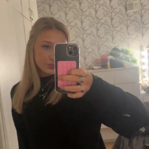 Svart stickad tröja med lång ärm - En svart stickad tröja med lång ärm och klassisk rund hals. Tröjan har en enkel och stilren design som passar till många olika outfits. 