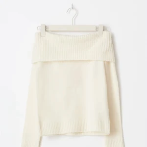 Offshoulder stickad vit tröja - Superfin offshoulder stickad tröja i vit färg med bred ribbad kant upptill och vid ärmslut. Perfekt för dig som vill ha en stilren och trendig look med en twist. Snygg att styla med jeans eller kjol för en chill vibe.