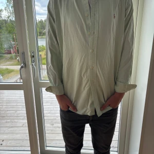 Ljusgrön skjorta från Ralph Lauren M - Snygg ljusgrön skjorta från Ralph Lauren i 100% bomull. Klassisk modell med knappar hela vägen, lång ärm och ikoniska broderade loggan på bröstet. Perfekt för dig som gillar stilrena och tidlösa plagg med en chill vibe.