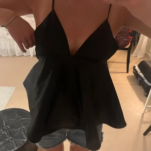 Svart v-ringad linnetopp H&M XS - Supersnygg svart linnetopp i glansigt material från H&M i storlek XS. den är tyvärr lite liten på mig så därför säljer jag! Har aldrig använt! 