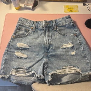 Ljusa jeansshorts från H&M Divided - Kan tänka mig att gå ner i pris ⚠️Snygga ljusblå jeansshorts från H&M Divided med hög midja (kan även användas som lågmidjad men blir då mer jorts)  och slitna detaljer framtill. Klassisk femficksmodell med fransig kant nertill och dragkedja med knapp. Perfekta för sommaren och ger en cool, avslappnad vibe. 