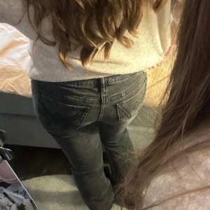 Svarta jeansbyxor med broderade bakfickor - Säljer ett par svarta jeansbyxor med snygga broderade detaljer på bakfickorna. Byxorna har normal passform och raka ben, perfekta till vardags. Klassisk femficksmodell och tillverkade i jeansmaterial. Har sprätta de längst ner så de skulle passa mig på längden 💕 skriv privat för bilder