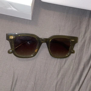 Mörkgröna solglasögon från CHIMI - Snygga solglasögon från CHIMI (04 green) i en mörkgrön, transparent plast med fyrkantig form och mörka glas. Perfekt accessoar för att lyfta din stil. Kommer med originalförpackning och fodral.