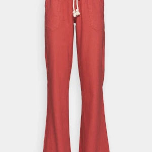 Korallfärgade linnebyxor - Säljer ett par snygga korallfärgade linnebyxor med raka ben och vit snörning i midjan. Byxorna har resår i midjan och praktiska fickor framtill. Perfekta för en avslappnad och trendig stil. Helt nya, aldrig använda! 