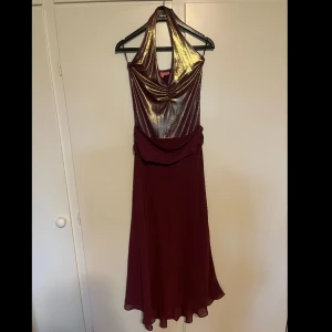 Lila glittrig långklänning från Chicas - Säljer en lila långklänning från Chicas med glittrigt halterneckliv och draperad midja. Klänningen har dekorativa stenar vid midjan och ett elegant fall. Perfekt för bal eller festkväll! Använd 1 gång. Priset kan diskuteras💕