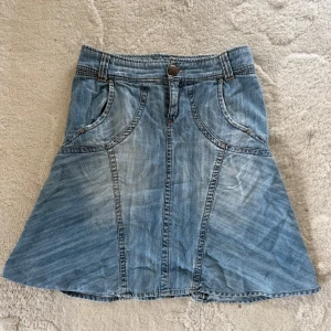 Jeanskjol från JAM - Säljer en  blå jeanskjol från JAM i A-linjeform med fina metalldetaljer. Kjolen är i storlek L🫶🏼