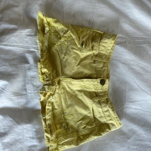 Gula jeansshorts med fransar och broderi - Snygga gula jeansshorts som är coola nu till sommaren tyvärr är de försmå för mig, dom är i storlek 34 och köpta secondhand så vet ej märke !