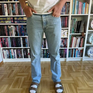 Ljusblå Levi's 501 jeans - Säljer ett par klassiska ljusblå Levi's 501 jeans med raka ben och normal passform. Jeansen har fem fickor, knappgylf och är tillverkade i slitstarkt bomullstyg. Perfekta för en avslappnad stil.