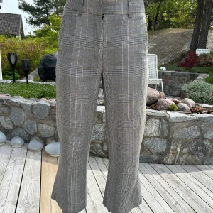 Grå rutiga kostymbyxor med slits - Snygga grå kostymbyxor med rutig mönster från H0pe. Croppad längd och slits.🤗