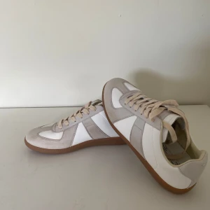 Maison Margiela - 👟 Maison Margiela GATs (German Army Trainers) - Storlek 42 👟  *   Skick: Använda en gång, som nya! *   Storlek: 42 – Perfekt om du vill ha en stilren och bekväm sneaker. *   Beskrivning: Säljer ett par grymma Maison Margiela GATs. Minimalistisk design och hög kvalitet. Perfekt för att lyfta vilken outfit som helst! *   Info: Ingen kartong, men original dustbag ingår. *   Frakt: Snabb frakt! *   Hör av dig om du har frågor eller vill ha fler bilder!