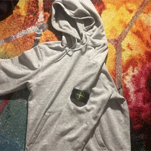 Ljusgrå hoodie stone island  - Mjuk och enkel ljusgrå sweatshirt från Nike med rund hals och ribbade muddar vid ärmslut och midja. Perfekt för en avslappnad stil och passar bra till både jeans och mjukisbyxor.