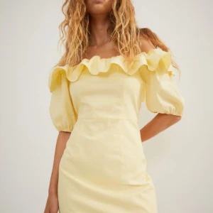 Ljusgul volang klänning - Supersöt kort klänning med volanger där uppe samt avtagbara axelband så att klänningen kan bli off shoulder 💞 köptes för några år sedan men har endast använts vid ett tillfälle så i princip i nyskick!🤗  hör av er vid frågor! Kan eventuellt gå ner lite i pris vid snabb affär eller vid köp av flera plagg:)