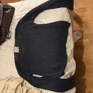 Svart stickad tröja från H&M - Säljer en svart stickad tröja från H&M med grovstickat mönster. Tröjan har lång ärm och en avslappnad passform, perfekt att slänga på sig över ett linne eller t-shirt.❤️storlek s-m❤️