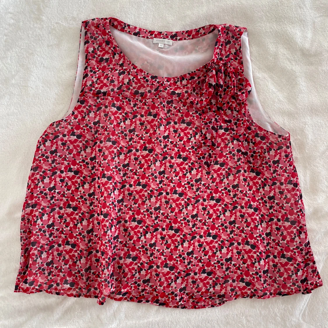 Blommig ärmlös blus med rosett