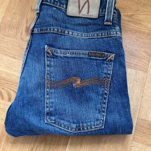 Nudie Jeans Grim Tim  - Säljer ett par blå jeans från Nudie Jeans i modellen Grim. Storlek W29 L32. Väldigt fin tvätt och riktigt bra skick