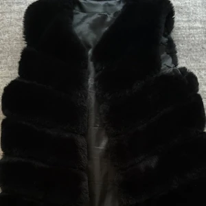 Väst  - Superfin svart väst i fuskpäls. One size och passar de flesta. Fortfarande i toppskick, bara använd några gånger. Perfekt till höst och vår! Säljes för 200 kr.